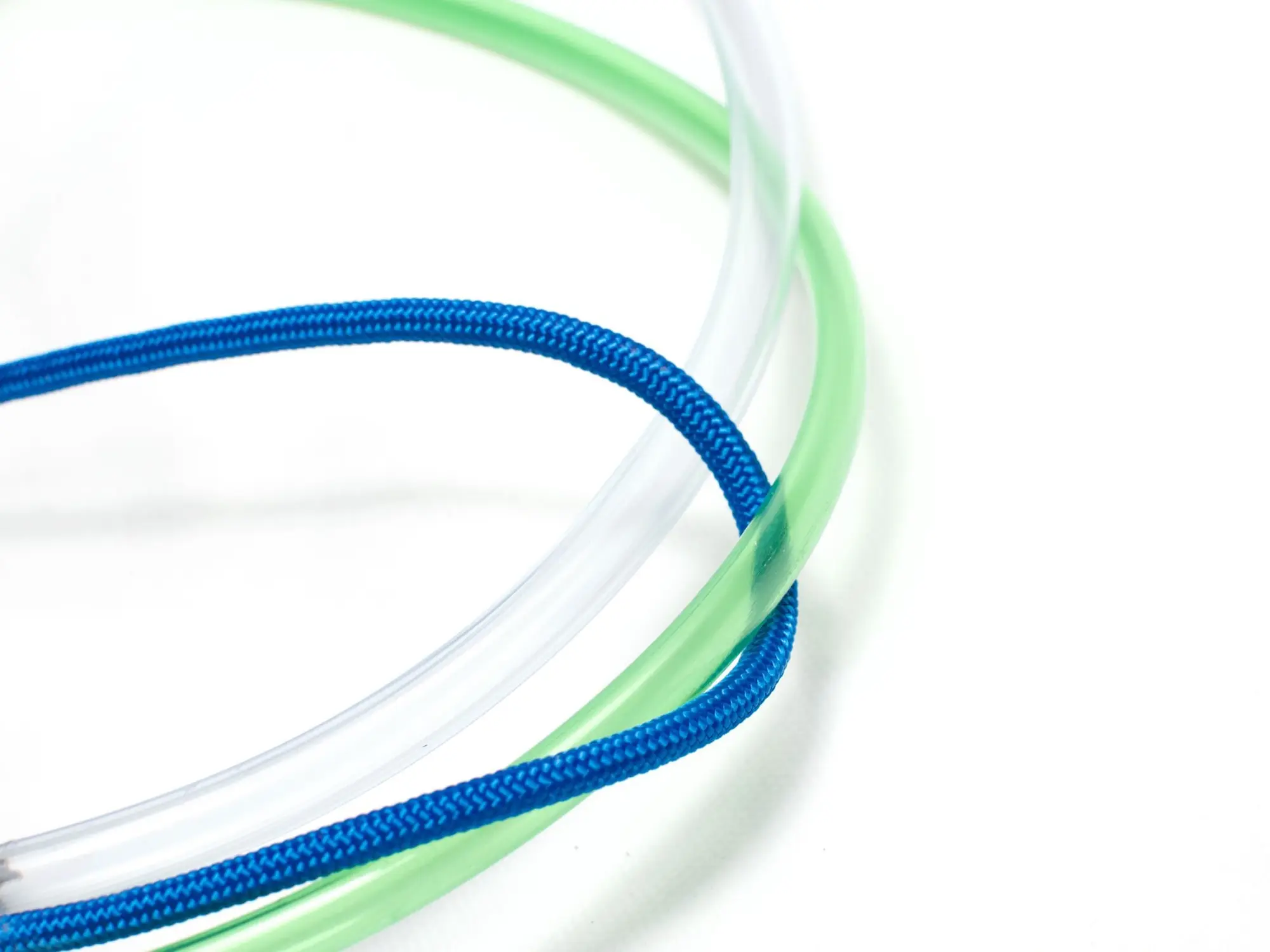 Tubos de plástico transparente y verde con una cuerda trenzada azul sobre fondo blanco